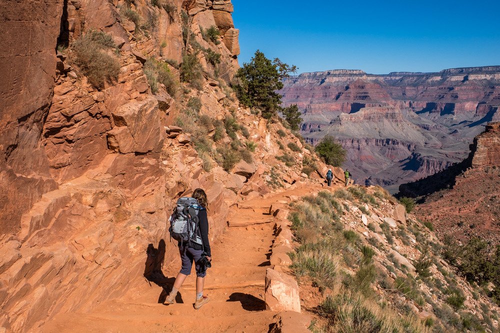 A hiker on a trail below the South Rim of the Grand Canyon