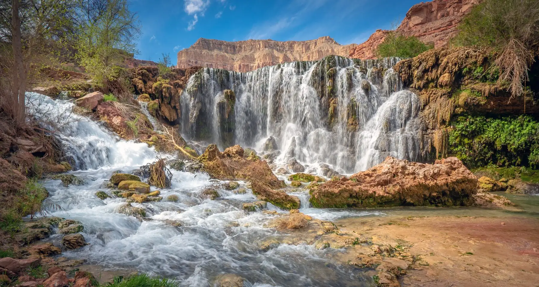 Fifty Foot Falls spilling in white curtains over a travertine wall into Havasu Creek
