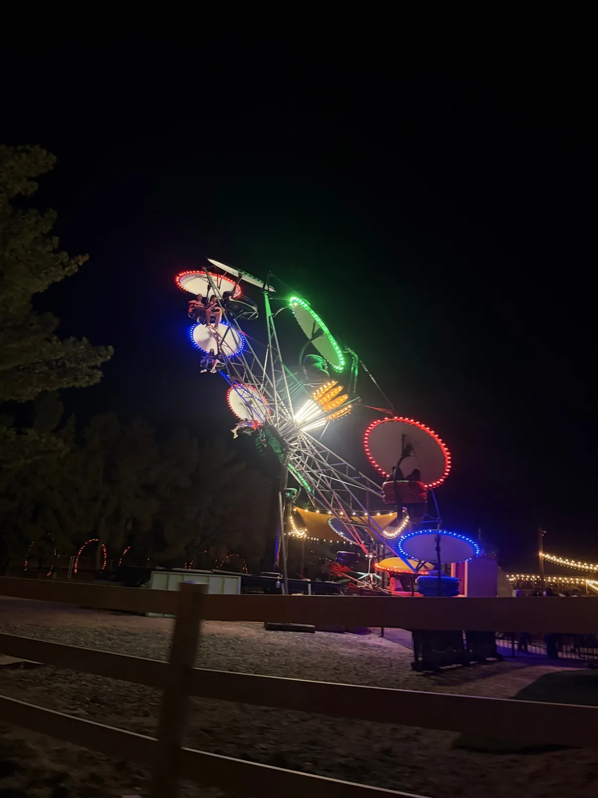 The Ferris wheel lit in red, green and blue against the night sky