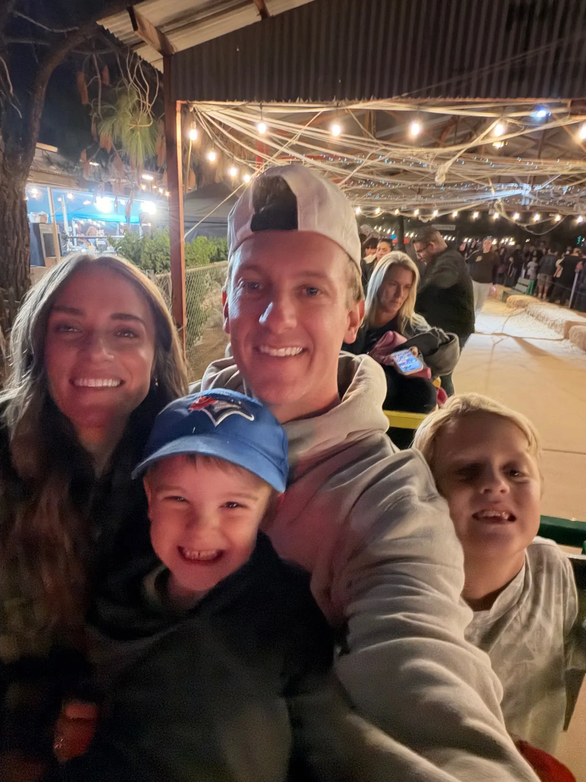 The crew packed onto the farm train at night under string lights