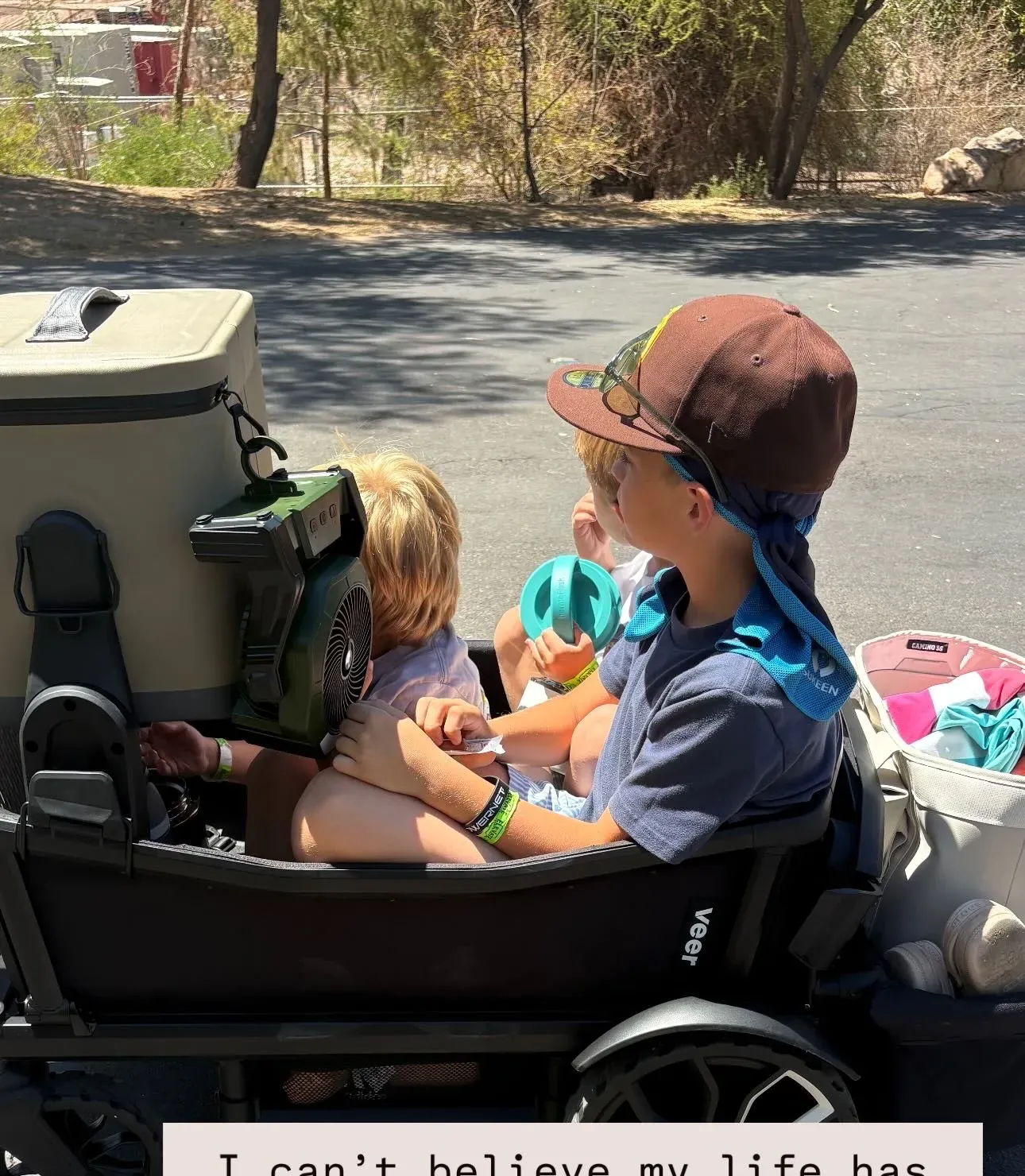 Two of the crew riding in the Veer Cruiser wagon, loaded with the cooler, a clip-on fan, and the rear storage basket for a day out